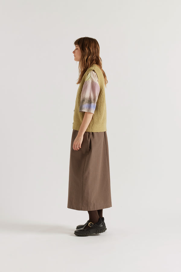 Side view of the chartreuse Faint Knit Vest worn buttoned over a shirt, showing reverse half-cardigan rib construction

