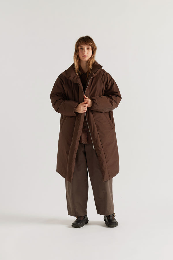 Front of  model in Chocolate Brown Floating Puffa Coat worn open, showing full-length silhouette, down-filled high collar and centre-front zip with magnetic fastenings