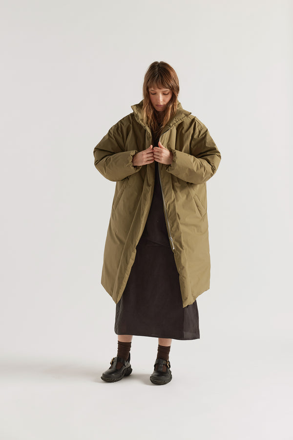 Front of  model in Olive Floating Puffa Coat worn open, showing full-length silhouette, down-filled high collar and centre-front zip with magnetic fastenings