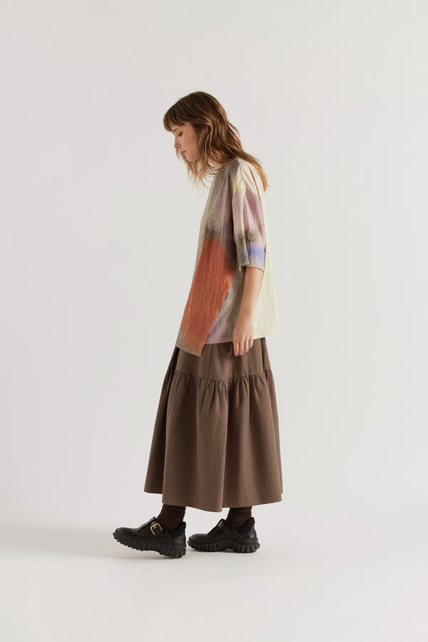 Three-quarter view of the Glimmer Top in Aion Print showing double-layered asymmetric split front, fluid drape and hip-length silhouette