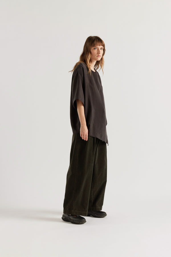 Front of the Glimmer Top in washed vintage black cupro featuring a double-layer asymmetrical front and fluid silhouette.