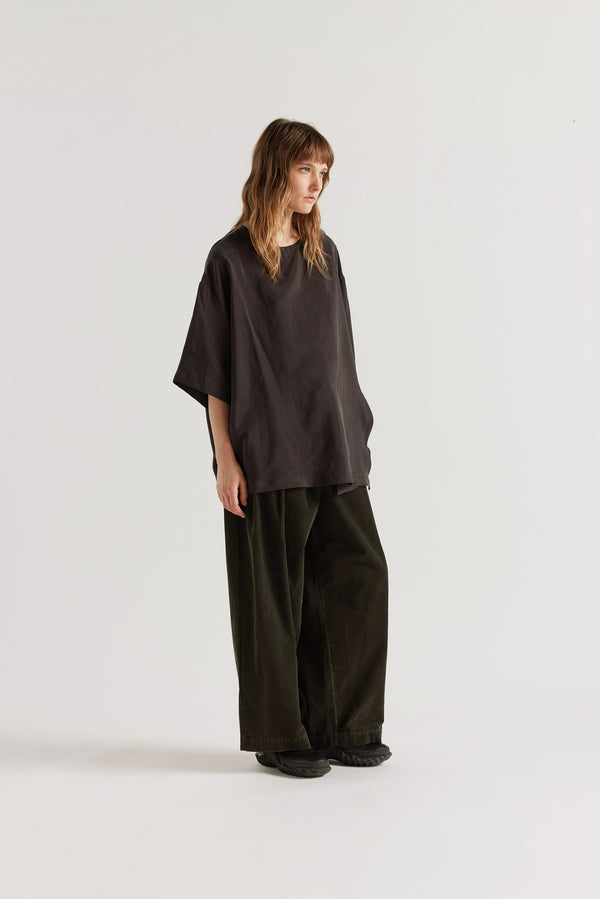 Front of the Glimmer Top in washed vintage black cupro featuring a double-layer asymmetrical front and fluid silhouette.