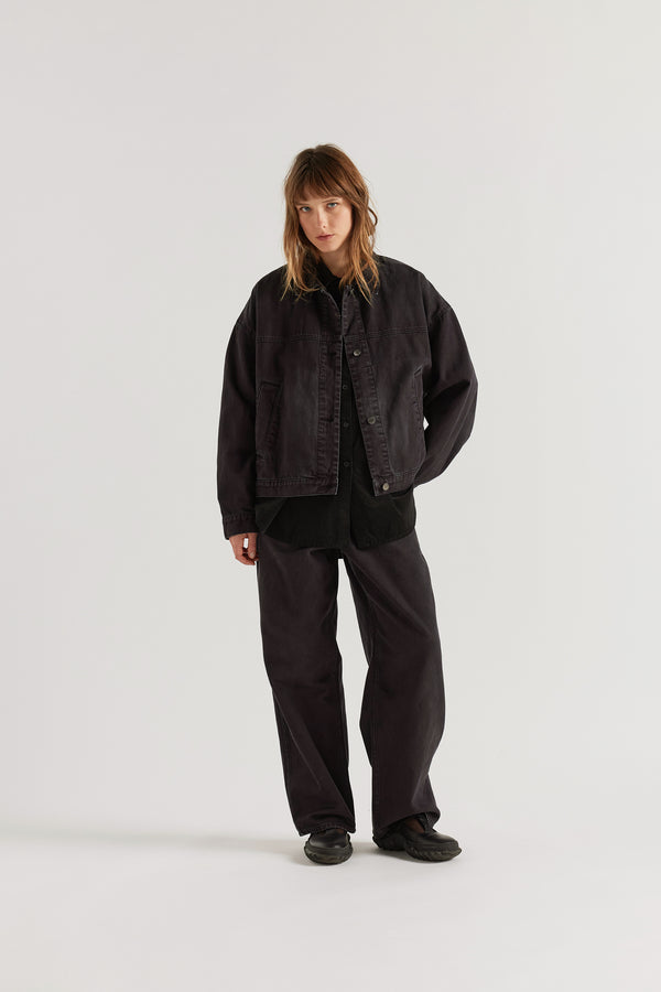 Front view of model in the black fade Oversized denim jacket with wide sleeves, deep welt pockets and a vintage-inspired over-dyed wash.