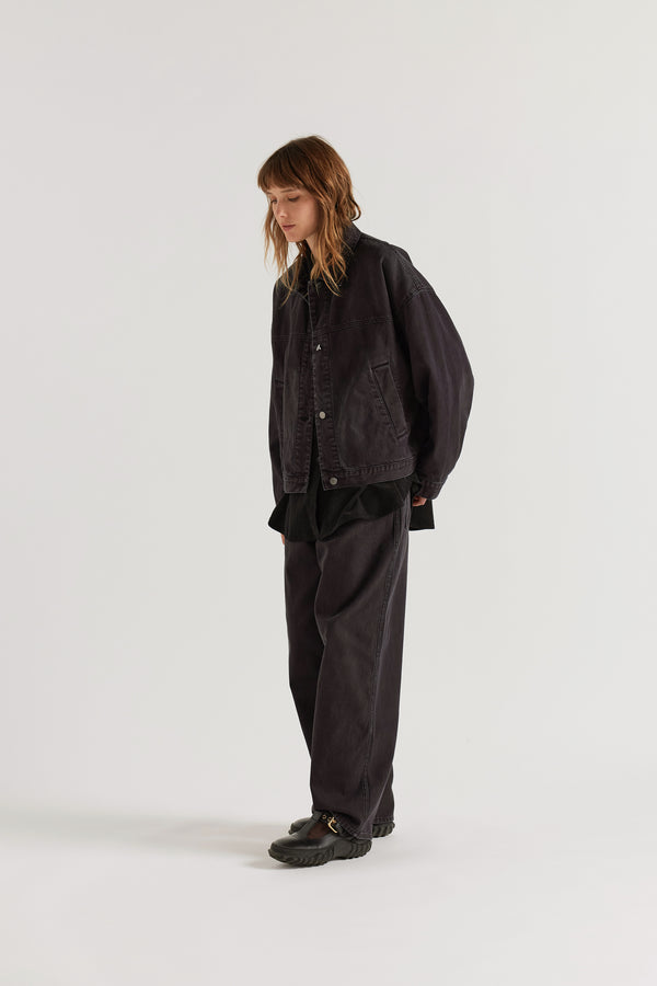 Front view of model in the black fade Oversized denim jacket with wide sleeves, deep welt pockets and a vintage-inspired over-dyed wash.