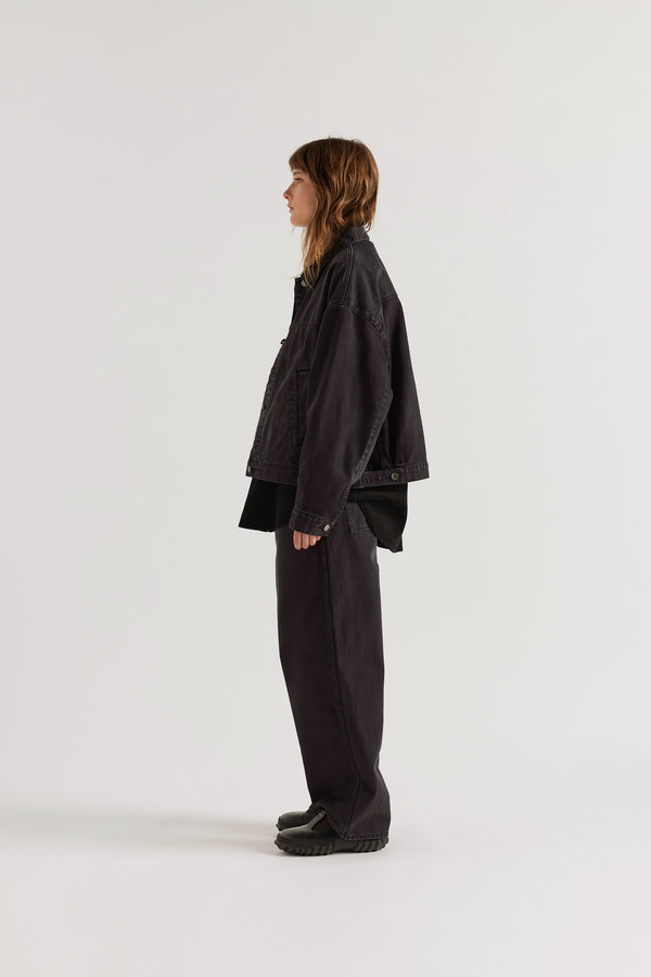 Side of model in the black fade Oversized denim jacket with wide sleeves, deep welt pockets and a vintage-inspired over-dyed wash.