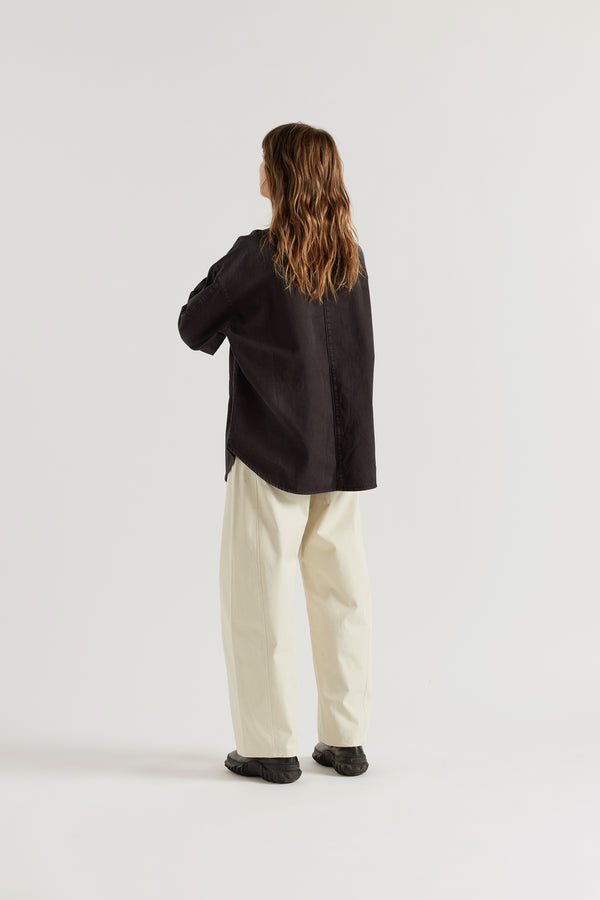 Back of model in the Black Fade Iris Denim Shirt with an oversized fit, dropped shoulders and utility-inspired chest pockets.
