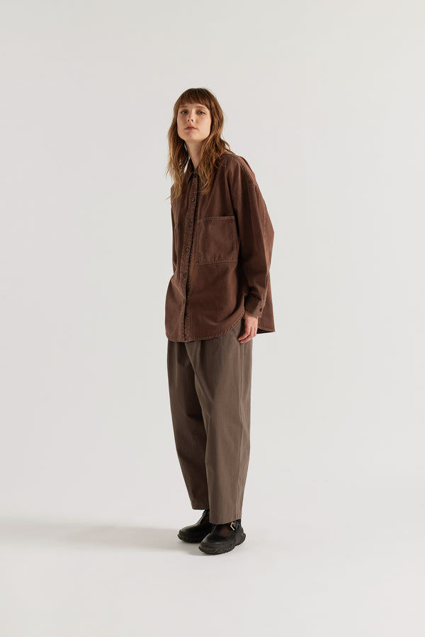 Front of model in the Brown Fade Iris Denim Shirt with an oversized fit, dropped shoulders and utility-inspired chest pockets.