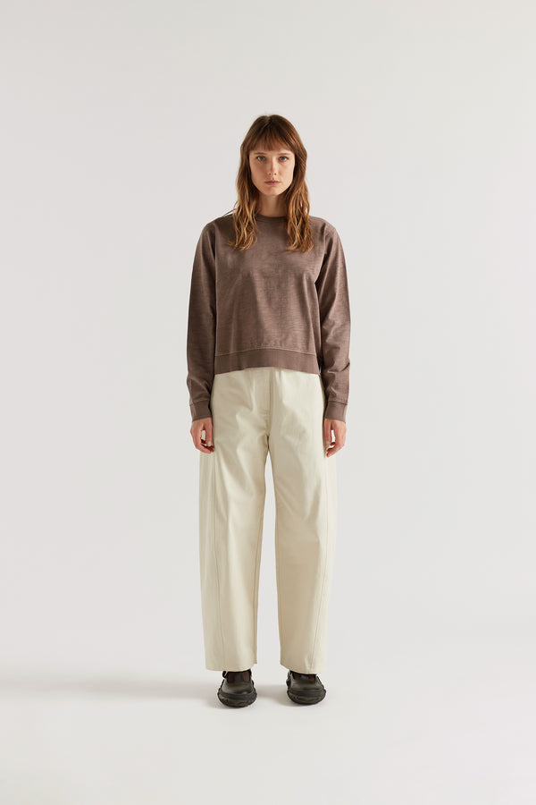 Front of female model in the brown Luster Long Sleeve Top in pigment-dyed cotton with a relaxed cropped silhouette and dropped sleeves.