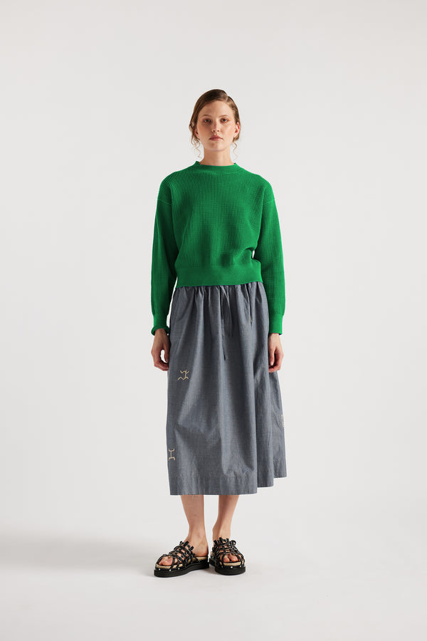 Model wears KLOKE embroidered skirt in blue grey, front view