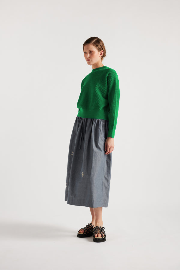 Model wears KLOKE embroidered skirt in blue grey, front angled view