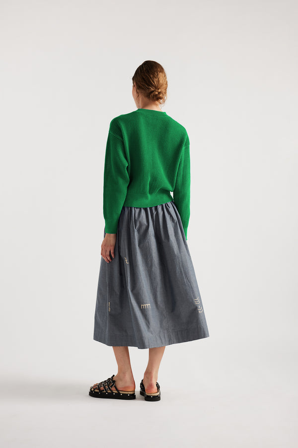 Model wears KLOKE embroidered skirt in blue grey, back view