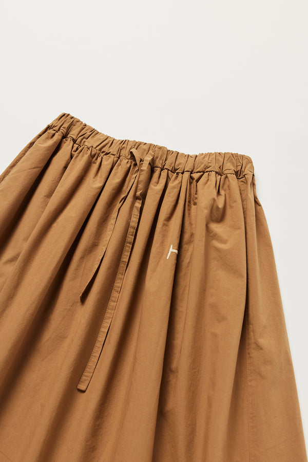 Detail of KLOKE embroidered skirt waistline and tie in walnut brown, with ecru embroidery