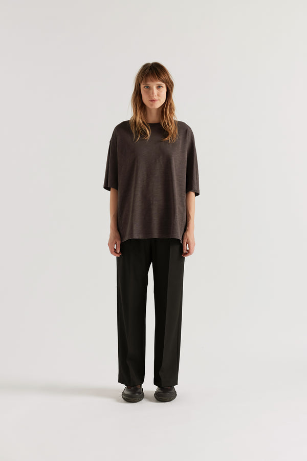 Front of model in the Black Manta Pant with a tailored silhouette, elasticated waistband and front pin tuck detailing.