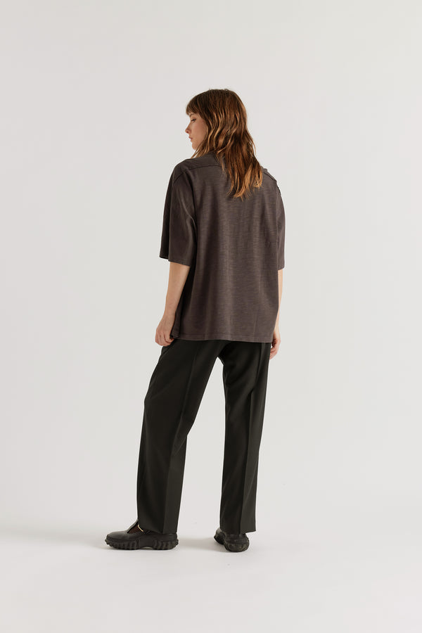 Back view of model in the black Manta Pant showing the clean tailored fit and elasticated waistband.