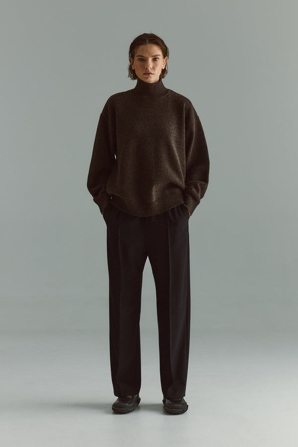 Front view of model in the black Manta Pant showing the clean tailored fit and elasticated waistband.