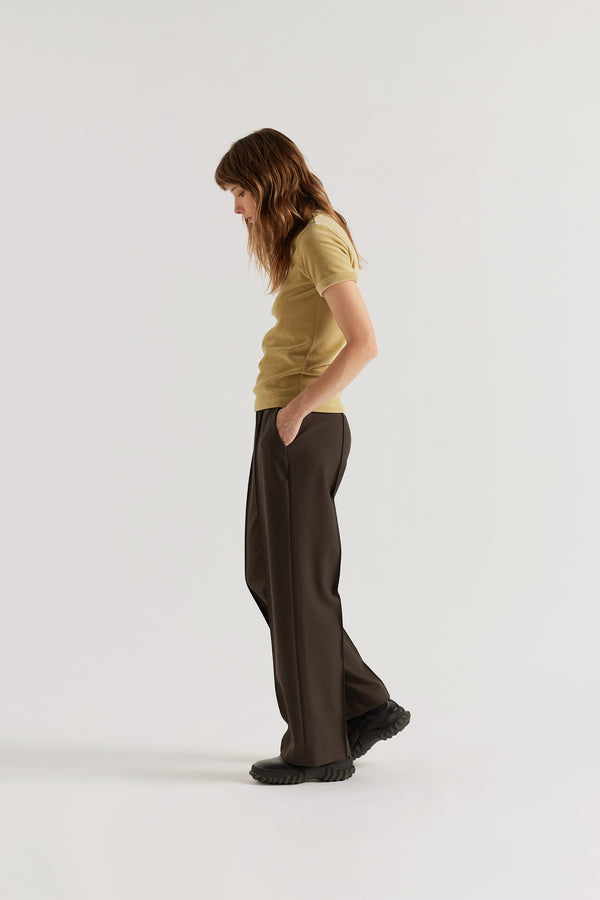 Side profile of the Dark Taupe Manta Pant featuring slant side pockets and a relaxed tailored silhouette.