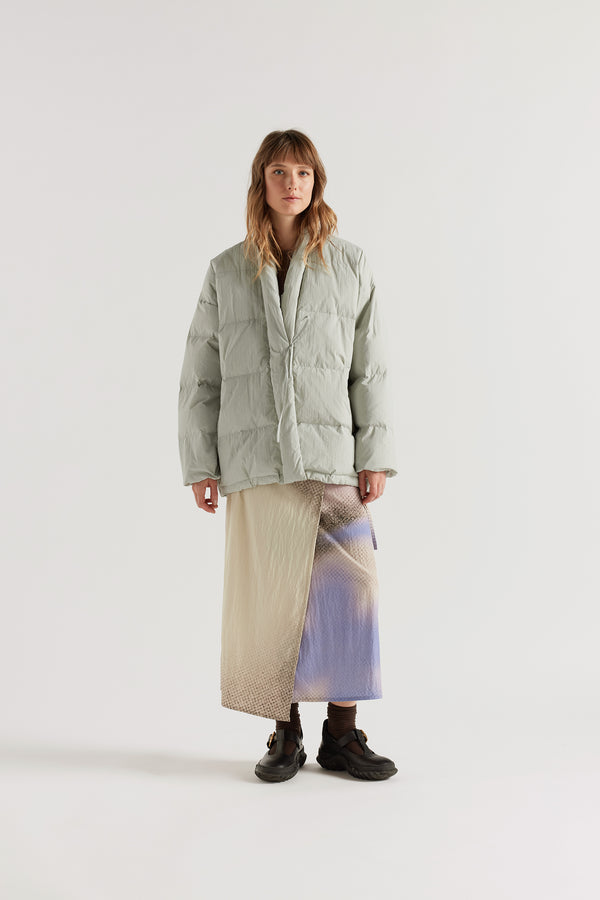 Front of model in Vintage grey Nimbus Kimono Jacket worn closed with centre-front self-tie, showing quilted recycled down construction and wrap silhouette