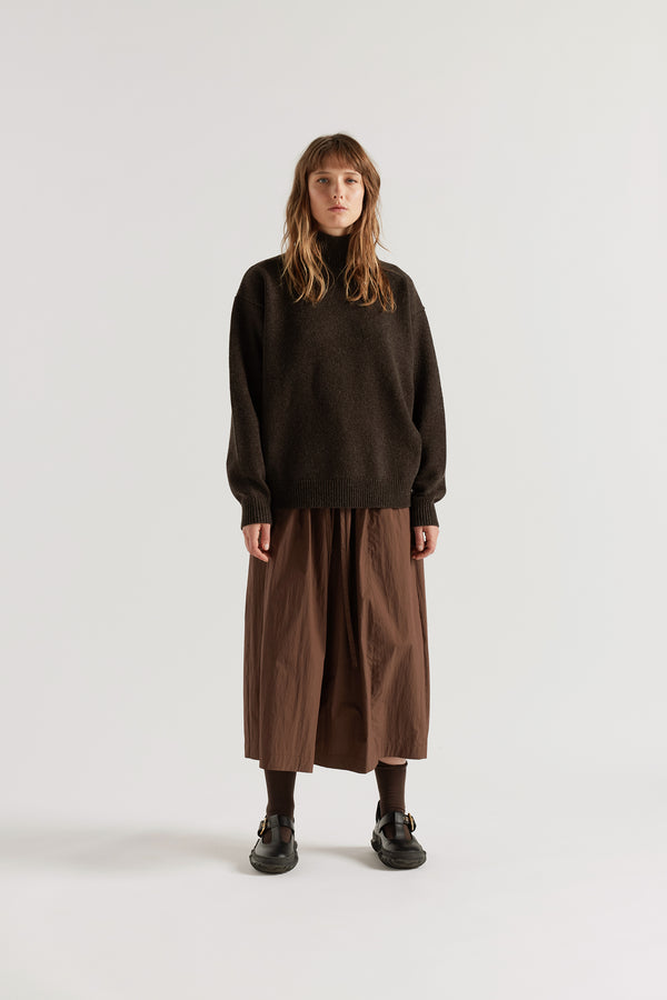 Front of model in Opal Mock Neck Sweater in Coffee, front view showing 1x1 rib high neckline, relaxed shorter silhouette and dense extrafine Merino knit