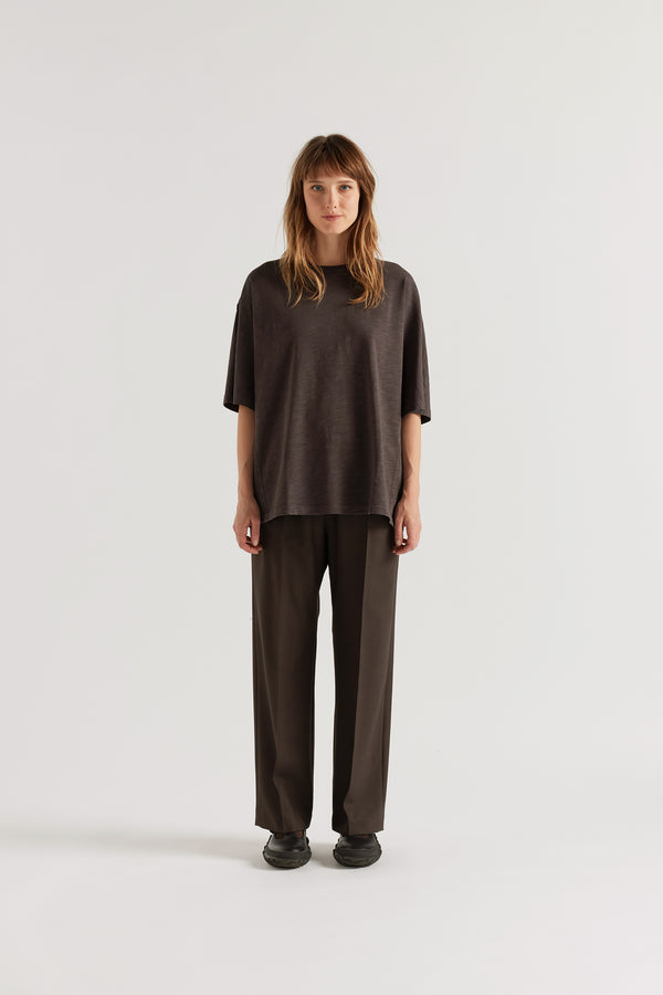 Front of female model in the black Overdyed Declare Tee in Nut Brown with a relaxed boxy fit and twisted sleeve detailing.