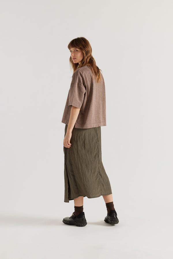 Back view of female model in the brown Obelisk Tee showing the relaxed boxy silhouette.