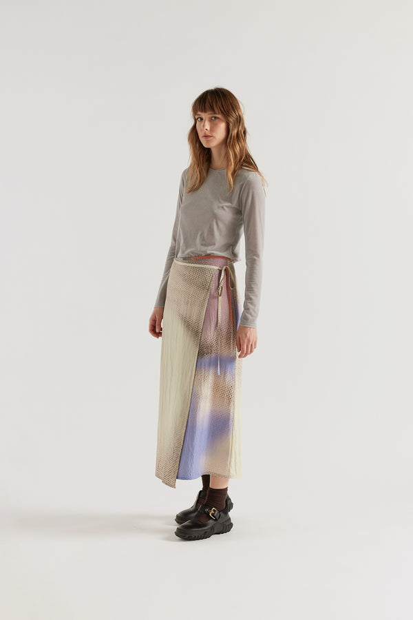 Purview Skirt in Aion Print front view showing wrap A-line midi silhouette with fragmented asymmetric deity print in distorted mauve, blue and orange