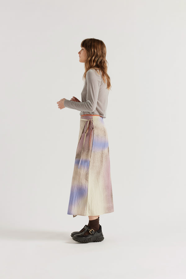 Side view of the Purview Skirt in Aion Print showing fluid drape of rayon-nylon blend and distorted asymmetric print across the A-line midi silhouette