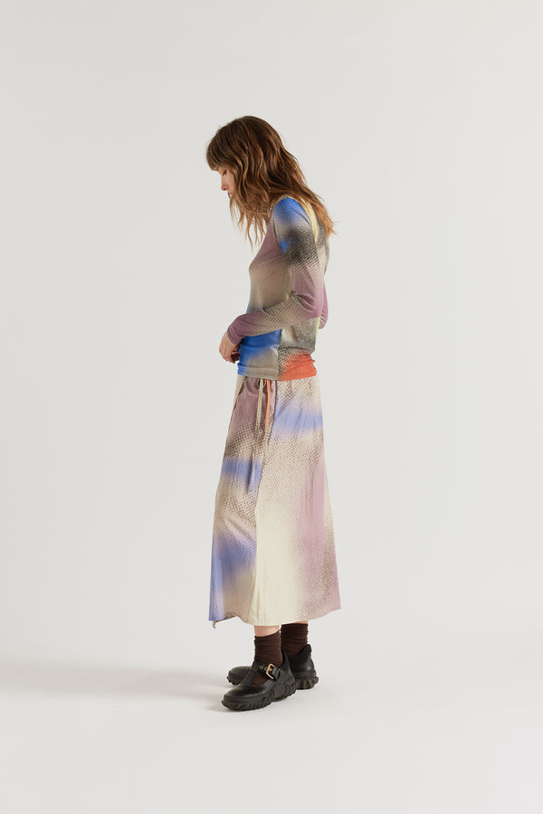 Side view of the Purview Skirt in Aion Print showing fluid drape of rayon-nylon blend and distorted asymmetric print across the A-line midi silhouette