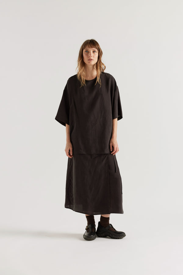Front of the Purview Skirt in Vintage Black Cupro showing wrap A-line midi silhouette. 