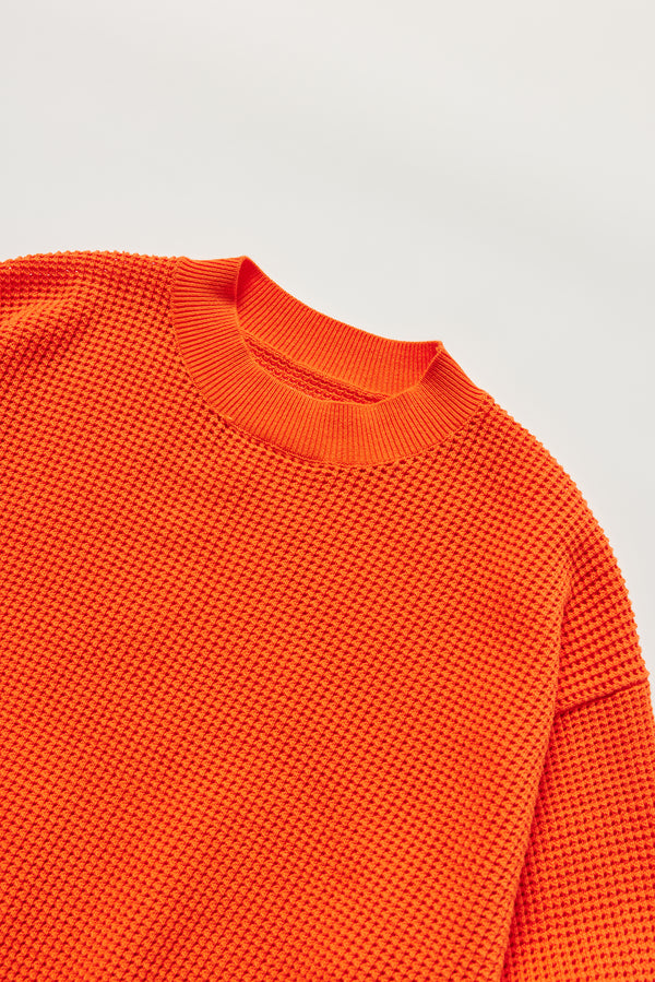 Detail of KLOKE pointelle-knitted cotton sweater neckline in dutch orange
