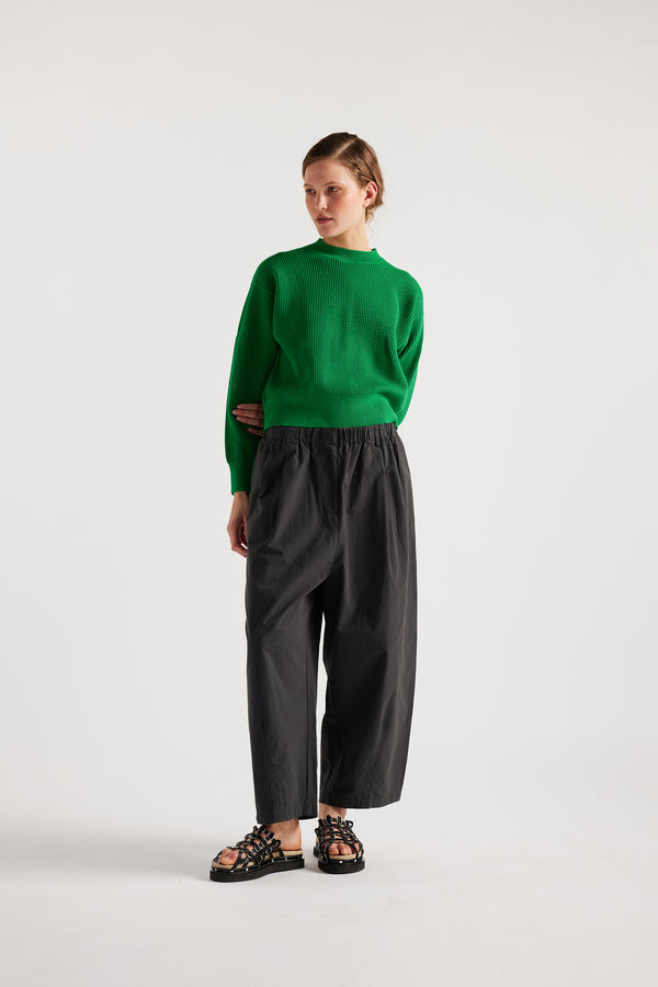 Model wearing KLOKE pointelle-knitted cotton sweater in vivid green, front view