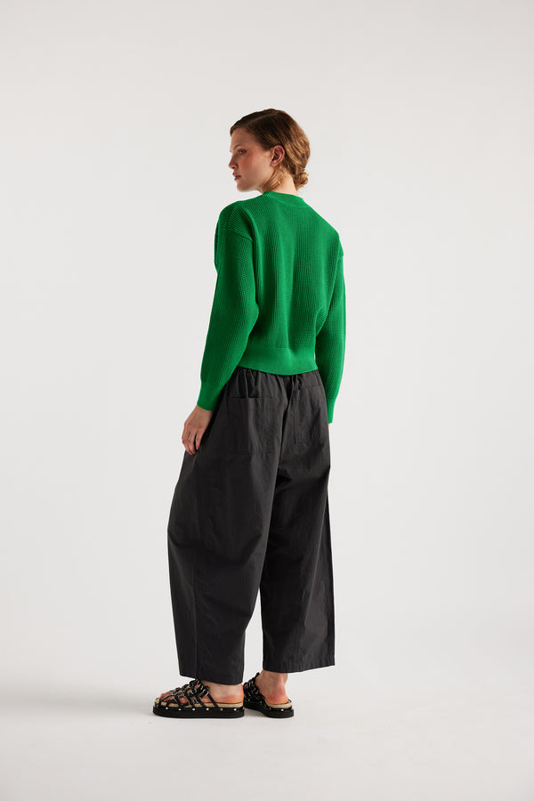 Model wearing KLOKE pointelle-knitted cotton sweater in vivid green, back view