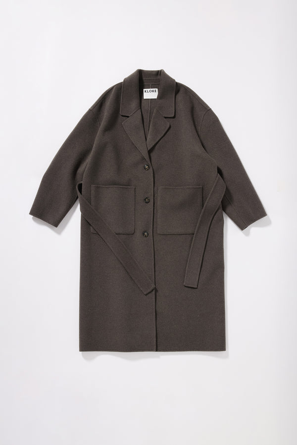 Flat front of the Retention Wool Coat in Olive Taupe closed, showing tailored single-breasted long silhouette, dropped shoulders and large front patch pockets