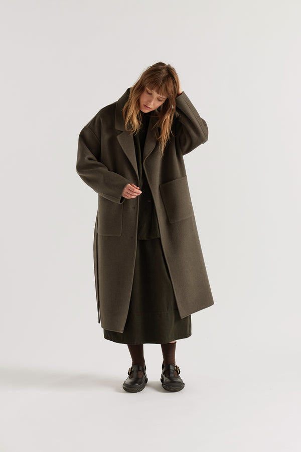 Retention Wool Coat in Olive Taupe worn open, showing hand-finished double-faced wool cashmere construction and full-length tailored silhouette