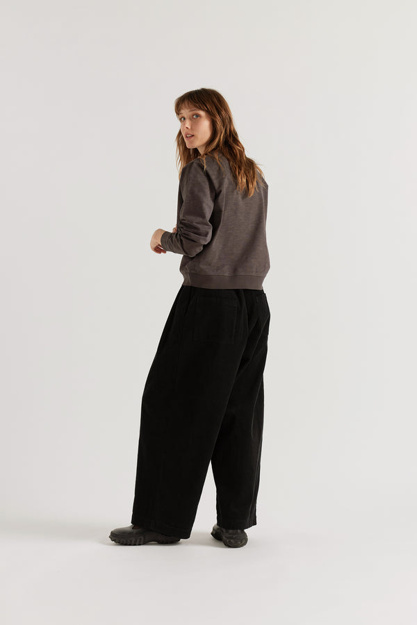 Back view of the Black Willow Cord Pant showing back patch pockets, wide balloon leg and deep colour from garment double over-dye process in corduroy