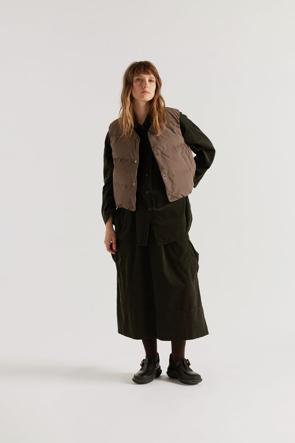 Front of female model in the brown Quilted down vest with a V-neck, snap-front closure and front welt pockets.