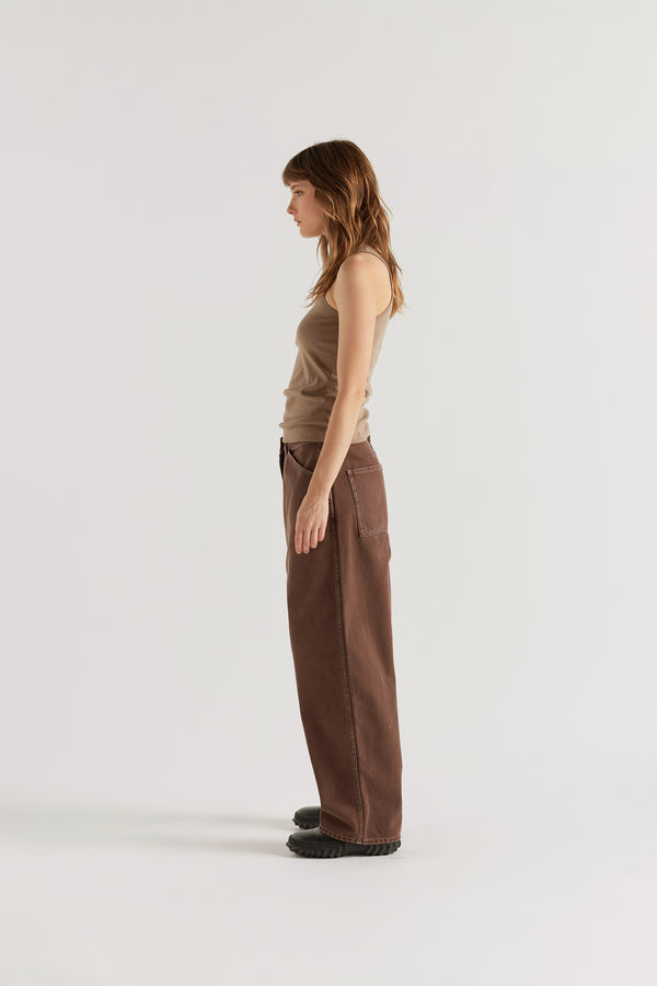 Side profile of the brown fade Unbound Jean showing the forward-facing twin-needle side seam and baggy fit.