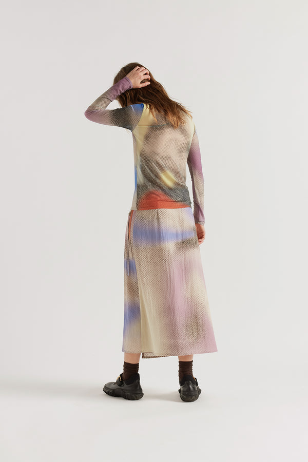 Back view of model in the Aion Print mesh top showing the slim silhouette and sheer fabric.