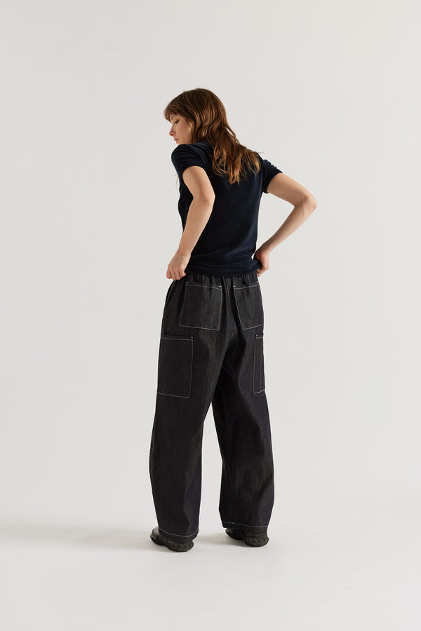Back view of relaxed dark indigo cargo pants featuring patch pockets and premium Japanese denim construction.